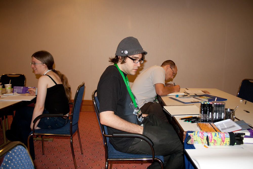 Tabbie, looking bored while sitting at a table in the Artist Lounge.