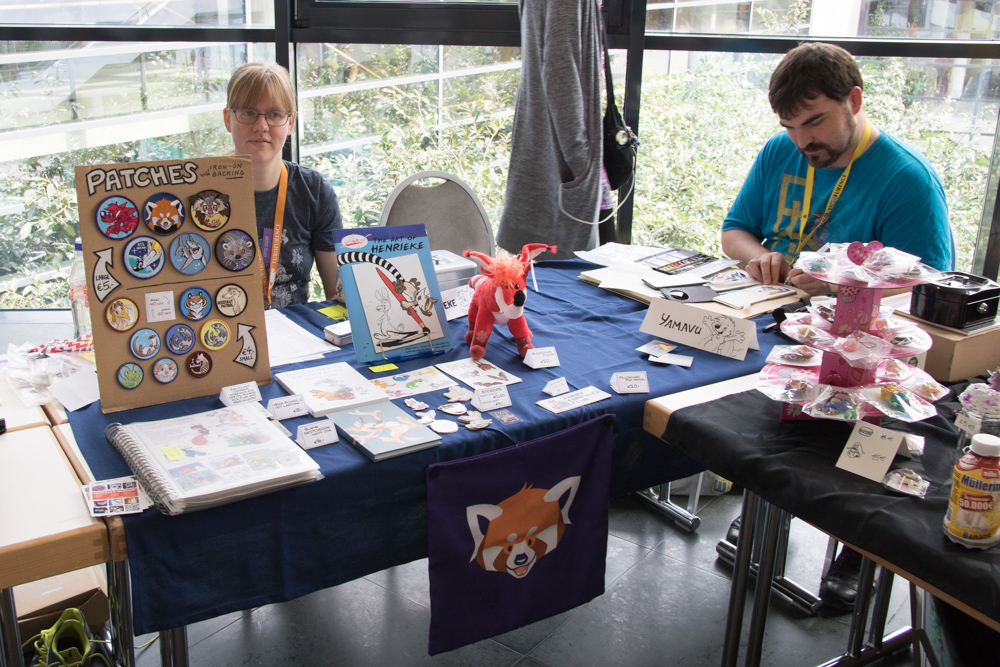 Henrieke and Yamavu sitting at their tables in the Artist Alley