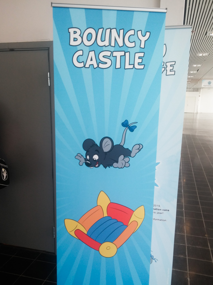 A vertical banner at the entrance of the bouncy castle playground showing Mausie