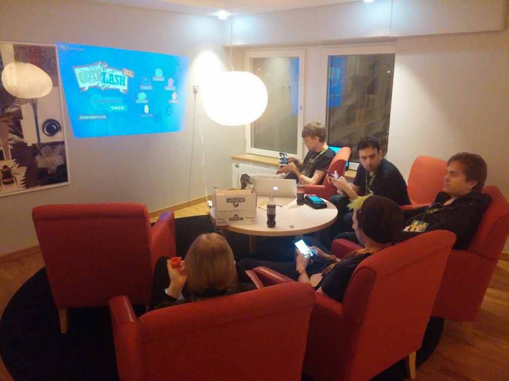 Henrieke, Mag, Yotie, Ekorren and Procyon sitting around a small table, playing Jackbox with a tiny DLP projector